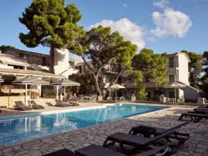 a swimming pool with lounge chairs and a hotel at AQUARIUS HOTEL in Vasilikos