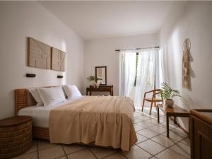 ein Schlafzimmer mit einem Bett und einem Tisch und einem Fenster in der Unterkunft AQUARIUS HOTEL in Vasilikos