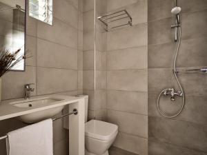 a bathroom with a toilet and a sink and a shower at AQUARIUS HOTEL in Vasilikos