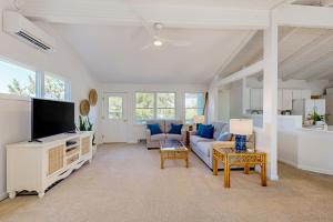 a living room with a couch and a tv at Ocean Village --- 39679 Willet Rd in Bethany Beach