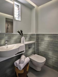 a white bathroom with a sink and a toilet at AQUARIUS HOTEL in Vasilikos