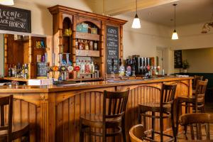 a bar in a restaurant with wooden chairs at The Black Horse in Swaffham Bulbeck