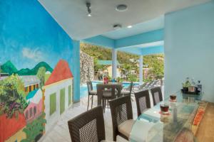 a dining room with a mural on the wall at Cane Garden Bay Beach Hotel in Cane Garden Bay