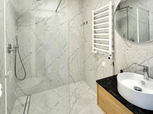 een witte badkamer met een wastafel en een douche bij OWysoko - Apartamenty z Widokiem 200 m od tras Szczyrk Mountain Resort in Szczyrk +61 foto's