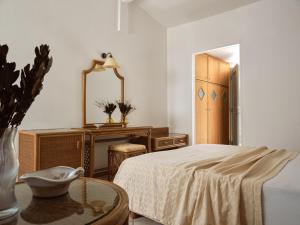 a bedroom with a bed and a table and a mirror at AQUARIUS HOTEL in Vasilikos
