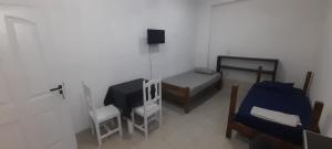 a small room with a bed and a table and chairs at Avenida colon in Santiago del Estero