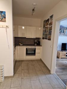 una cucina con armadietti bianchi e pavimento piastrellato di Altmünster mit Traunsteinblick ad Altmünster