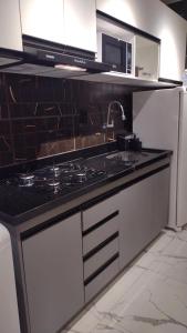 a kitchen with a stove and a sink and a microwave at Studio Pelourinho, Salvador in Salvador