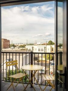 a balcony with a table and chairs and a view of a city at Downtown, contemporary, 2 bedroom, Roof Terrace! 3A in Savannah