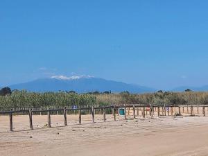 a row of fences on a beach with mountains in the background at La casa terracotta in Claira +8 photos