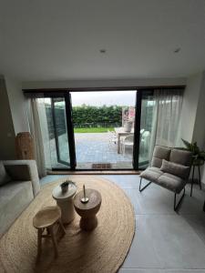 a living room with a large window and a table at Naast 37 Overnachten in Driebergen