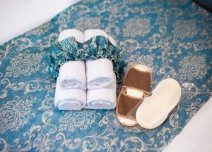 利沃夫Світла затишна квартира в центрі біля Оперного театру з балконом, який виходить у тихий львівський дворик的蓝色地毯上放着一双凉鞋和几条毛巾。