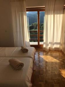 two beds in a room with a large window at House Katy in Peračko Blato