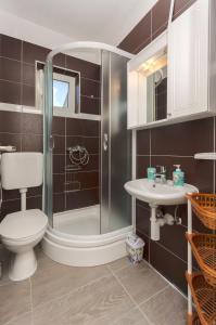 une salle de bains avec douche, toilettes et lavabo dans l'établissement Apartments Sunny Corner, à Tribunj 56 autres photos