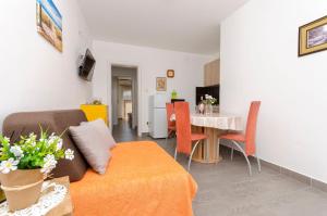 un salon avec un canapé et une table dans l'établissement Apartments Sunny Corner, à Tribunj