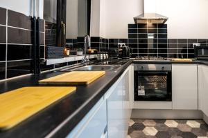 a kitchen with a sink and a counter top at The Cave in Coventry +25 photos