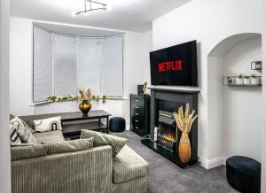 a living room with a couch and a fireplace at The Cave in Coventry
