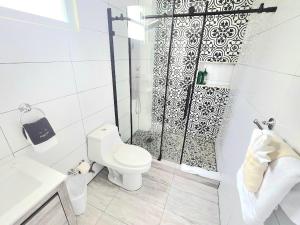 a white bathroom with a shower and a toilet at Somos Hotel San Juan in San Juan +52 photos