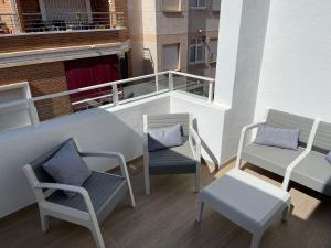 a balcony with two chairs and a table and benches at Boutique Apartment Torrevieja Centro in Torrevieja