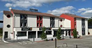ValentigneyVal Hôtel Montbéliard Sud的街道旁停车场的建筑物