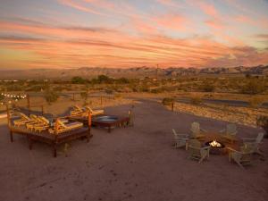 um grupo de mesas e cadeiras no deserto ao pôr do sol em Total Serenity Cowboy Pool Fire Pit Views em Joshua Tree