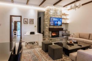 a living room with a couch and a fireplace at Melithos Villa in Koropi