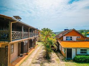 a row of houses with a palm tree in front at Pousada Recanto do Rosa in Praia do Rosa