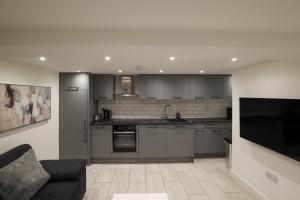 a kitchen with stainless steel appliances and a couch at Stylish 1 Bed Apartment in Bicester Town Centre in Bicester
