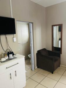 Una sala de estar con un sofá y un baño. en Ndiles-69Tennyson, en East London