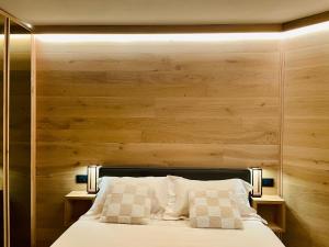 a bedroom with a bed with a wooden wall at Panoramic Apartment in Breuil-Cervinia