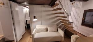 a living room with a white chair and stairs at Chalet in Courmayeur near Lifts & Centre 2BR 2BA in Courmayeur