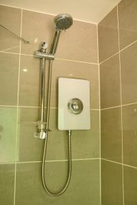 a shower with a shower head in a bathroom at Charming 2BD House - Parking & Garden in Oban in Oban +12 photos