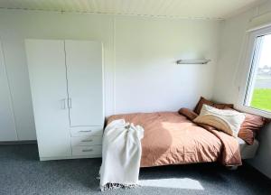 a bedroom with a bed and a cabinet and a window at Small studio close to Stegra - H2GS in Boden
