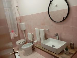 a bathroom with a sink and a toilet and a mirror at Vittoria House in Sciacca +13 photos