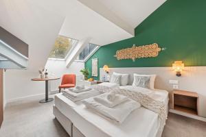 Un dormitorio con dos camas y una pared verde. en VIVE Hotel & Restaurant Vienna, en Viena