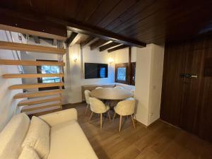 a living room with a couch and a table and chairs at Chalet in Courmayeur near Lifts & Centre 2BR 2BA in Courmayeur +27 photos
