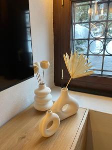 two white vases sitting on a table with a window at Chalet in Courmayeur near Lifts & Centre 2BR 2BA in Courmayeur