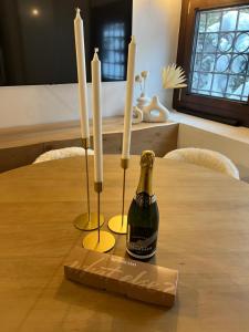 a bottle of champagne and three candles on a table at Chalet in Courmayeur near Lifts & Centre 2BR 2BA in Courmayeur