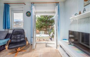 a living room with a chair and a sliding glass door at Stunning Apartment In Barbariga in Barbariga