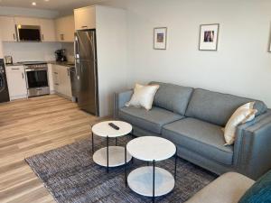 a living room with a couch and two tables at Lakefront Nest Beach House Suite in Penticton
