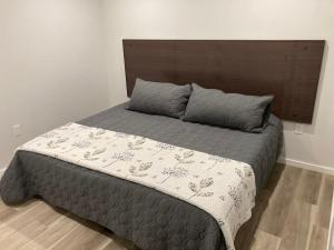 a bedroom with a large bed with a wooden headboard at Lakefront Nest Beach House Suite in Penticton