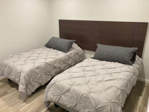 two beds sitting next to each other in a room at Lakefront Nest Beach House Suite in Penticton +16 photos