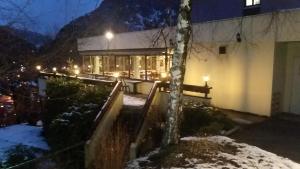 een gebouw met een boom in de sneeuw 's nachts bij Hotel Inn Design Moutiers in Moutiers