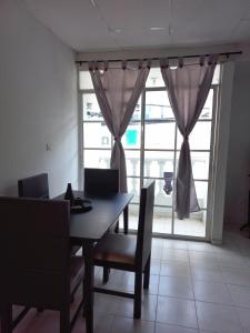 哥伦比亚港Apartamento hostal oasis的一间有桌子、椅子和窗户的餐厅