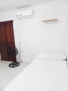 哥伦比亚港Apartamento hostal oasis的一间设有床、门和椅子的房间