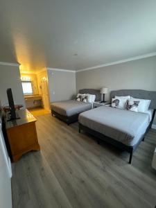 a bedroom with two beds and a television in it at Dune Surfer Inn in Oceano