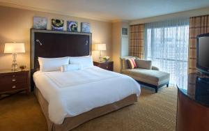 a hotel room with a large bed and a chair at Norfolk Waterside Marriott in Norfolk