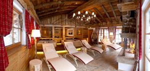 a dining room with white chairs and a chandelier at Verwöhnhotel Kristall in Pertisau