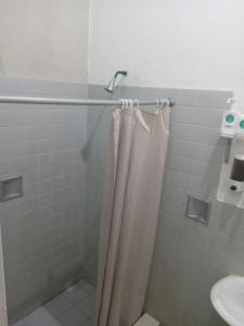 un bagno con tenda da doccia e lavandino di Hostal Brunette Santein a Santa Ana