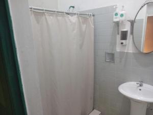 un bagno con tenda da doccia e lavandino di Hostal Brunette Santein a Santa Ana Altre 23 foto